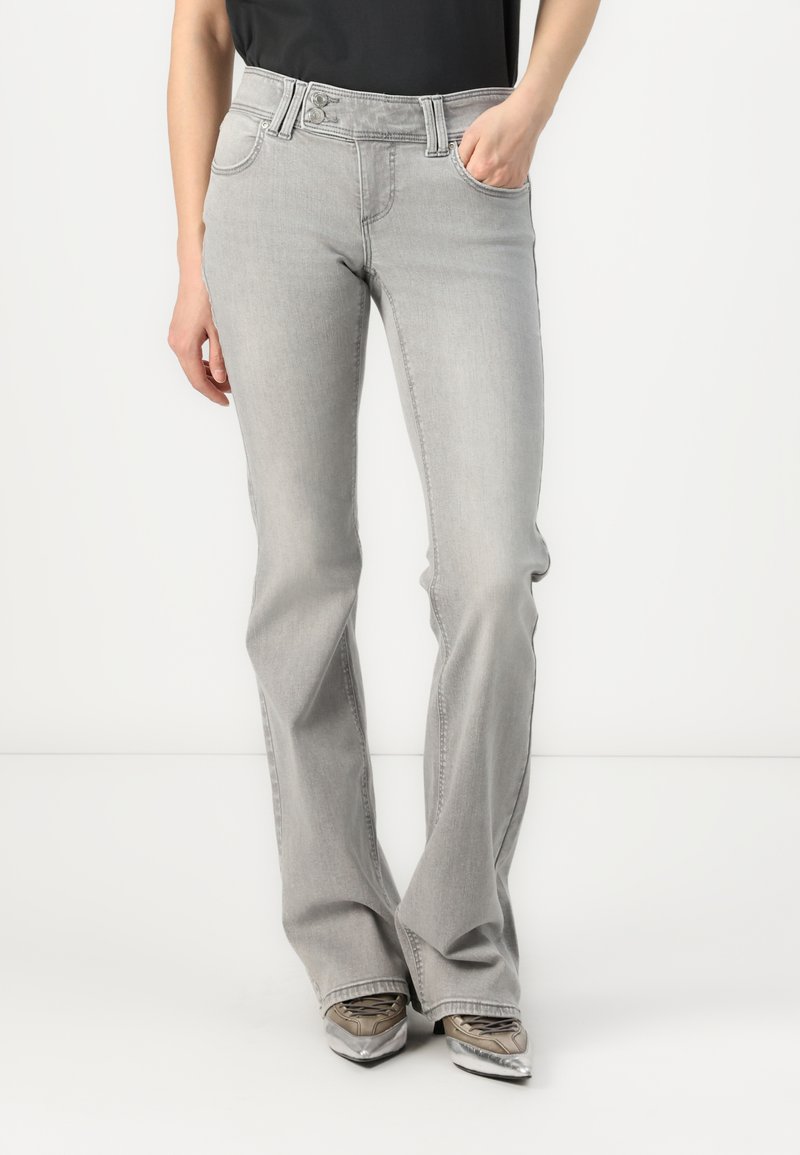 Lys grå slengjeans med en jevn tekstur, fem lommer og knappelukking. Har subtile sømmer og et klassisk design.