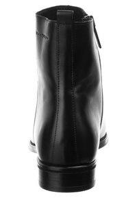 Černá kožená kotníková bota s hladkým povrchem, s vertikálním švem, úzkým svrškem a mírným podpatkem. Obsahuje zadní zip pro zapínání.