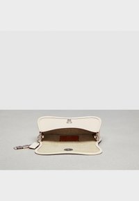 Kremowa skórzana kopertówka z falistym wzorem, z metalicznym zapięciem, beżową tkaninową wyściółką i małą skórzaną metką wewnątrz.