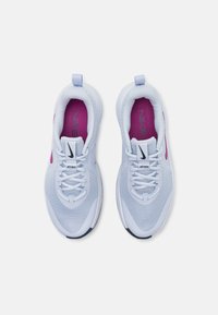 Hvite mesh sneakers med rosa detaljer, med avrundet tå, snøring og en fremtredende Nike-logo på tungen og siden.