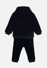 Conjunto de forro polar azul marino que incluye una sudadera con capucha, puños de ribete y capucha ajustable, junto con pantalones a juego con puños elásticos.
