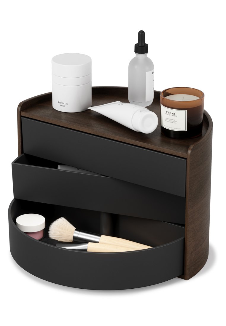 Organisateur de rangement circulaire avec un haut en bois sombre, un corps noir et des tiroirs. Contient divers produits de soins de la peau et pinceaux de maquillage.