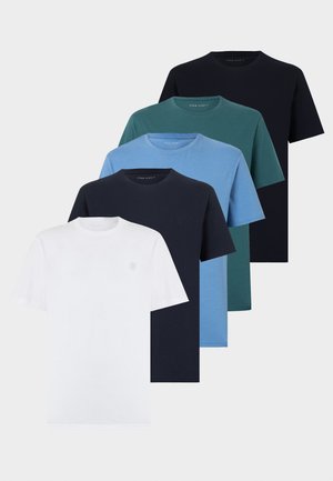 Cinq t-shirts à col rond manches courtes en blanc, marine, bleu clair, sarcelle et noir, superposés sur un fond blanc.