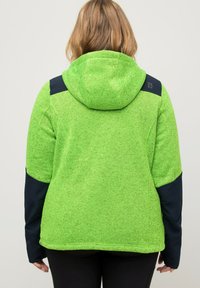 Giacca in pile verde con finiture testurizzate, con cappuccio e pannelli di accento blu scuro sulle spalle e sulle maniche.