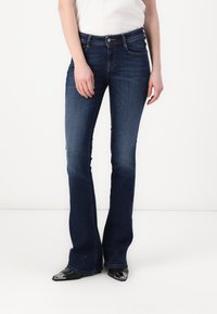 Dunkelblaue Bootcut-Jeans mit mittlerer Taille, aus Denim mit leichter Verwaschung, fünf Taschen und metallischen Hardware-Akzenten.
