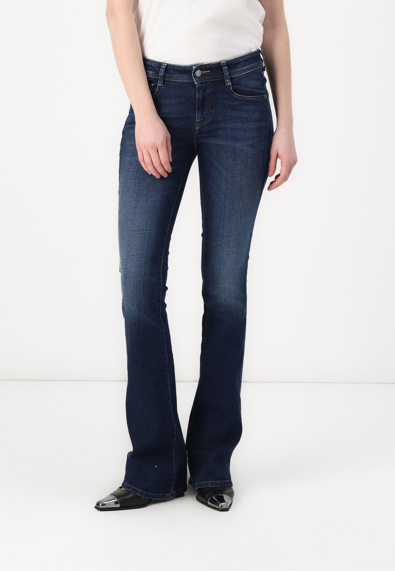 Dunkelblaue Bootcut-Jeans mit mittlerer Taille, aus Denim mit leichter Verwaschung, fünf Taschen und metallischen Hardware-Akzenten.