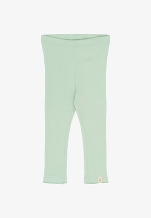 Helle grüne gerippte Leggings mit körperbetontem Design, gewelltem Saum und einem kleinen Etikett mit "PP" an der unteren linken Seite.