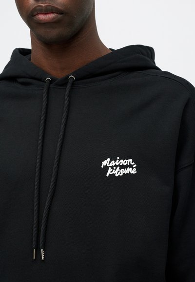 Hanorac negru din amestec de bumbac, cu o pungă frontală și glugă ajustabilă cu șnur. Logo-ul alb "Maison Kitsuné" pe piept.