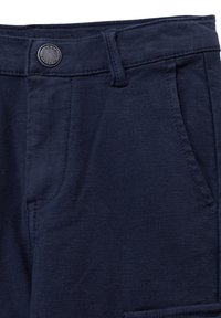 Marineblauwe broek van een gestructureerde stof, met een vlakke voorkant, zijzakken en een metalen knoop op de tailleband.