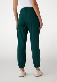 Zöld cargo nadrág, rugalmas mandzsettákkal, zsebekkel és testhezálló derékrésszel. Puha, tartós anyagból készült.