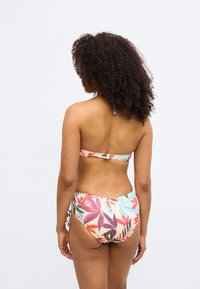Krāsains bikini ar ziedu rakstu rozā, sarkanos, zilos un zaļos toņos. Top bez lencēm, apakšdaļai regulējami aukliņu stiprinājumi.