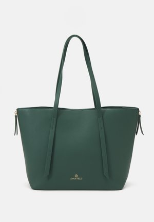 Borsa a tracolla verde realizzata in materiale sintetico liscio. Dotata di manici lunghi, chiusura con zip e logo dorato sulla parte anteriore.