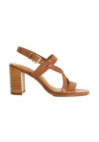 Tan leather high-heeled sandal with a block heel. Features crisscross straps, adjustable ankle buckle, and textured heel design.
