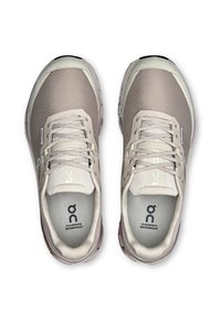 Baskets de sport imperméables gris clair avec une tige en maille texturée, un système de laçage et des semelles intérieures rembourrées arborant un logo de marque.