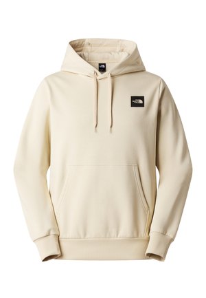 Krémově zbarvená mikina s kapucí z měkké tkaniny, vybavená přední kapsou, žebrovanými manžetami a černou nášivkou s logem na hrudi.