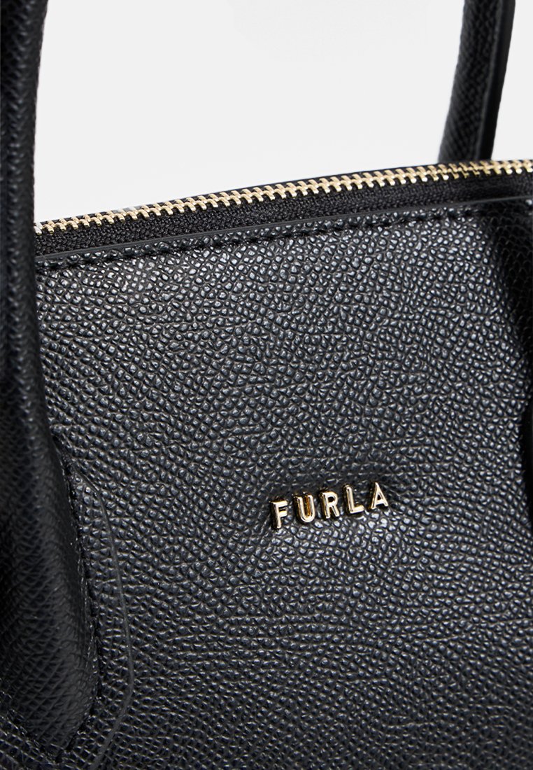 Schwarze Lederhandtasche mit strukturierter Oberfläche, goldfarbener Reißverschluss und sichtbar angebrachtem Logo. Ausgestattet mit zwei Griffen zum Tragen.