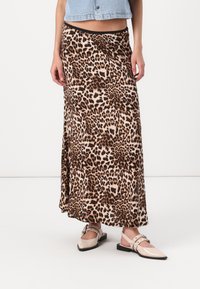 Maxi suknja s leopard uzorkom, letenog dizajna, izrađena od mekog materijala. Ima crni pojas i bočni prorez za lakše kretanje.