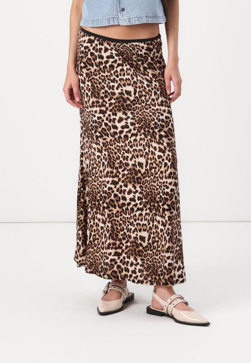 Maxi suknja s leopard uzorkom, letenog dizajna, izrađena od mekog materijala. Ima crni pojas i bočni prorez za lakše kretanje.