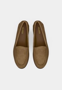 Paire de mocassins en daim marron avec bouts arrondis et logo ALDO à l'intérieur, vus de dessus sur un fond blanc.