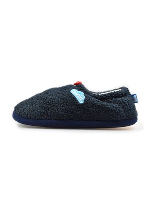 Zapatilla borrosa azul marino con suela plana, un pequeño broche rojo en la parte superior y un logotipo bordado en azul claro en el lateral.