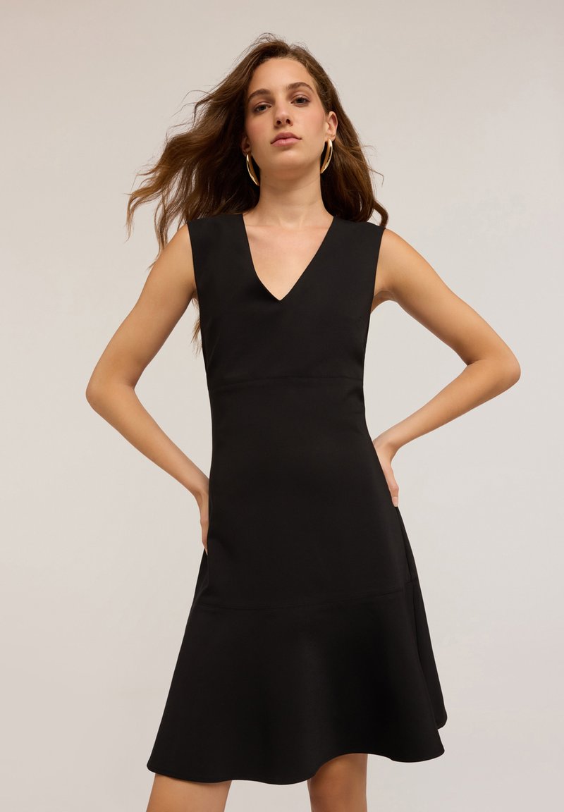 Rochie neagră fără mâneci, cu decolteu în V, bust strâns și fustă evazată. Textură netedă, mată și fără modele sau broderii vizibile.