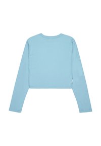 Svetlomodrý krátky dlhý rukáv top z mäkkého materiálu. Má okrúhly výstrih a rovné lemy, s malou nášivkou na bočnom šve.
