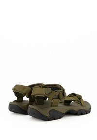 Sandalias verdes con correas ajustables, suelas de goma y una plantilla texturizada. Presentan un diseño robusto y acentos de estilo senderista.