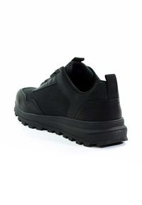 Schwarzer Sportschuh mit strukturiertem Obermaterial, verstärkter Ferse und Gummisohle mit tiefen Stollen für besseren Halt. Gummischlaufe an der Hinterseite.