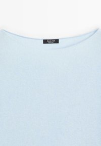 Maglione a lavorazione a maglia blu chiaro con scollatura rotonda e etichetta nera Massimo Dutti cucita all'interno del colletto.