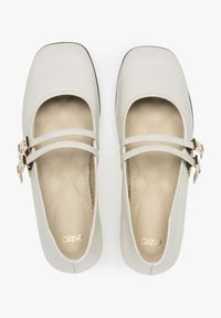 Jasnoszare buty typu Mary Jane z kwadratowym czubkiem, z dwiema cienkimi paseczkami i złotymi klamrami, wykonane z gładkiej sztucznej skóry, z wyściełaną wkładką.
