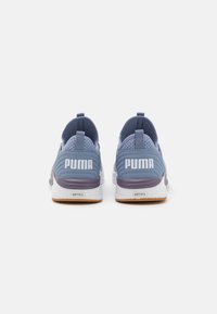Sneaker sportive blu chiaro con finitura testurizzata, dotate di tallone imbottito, suola in gomma e logo "PUMA" bianco ben visibile sul retro.