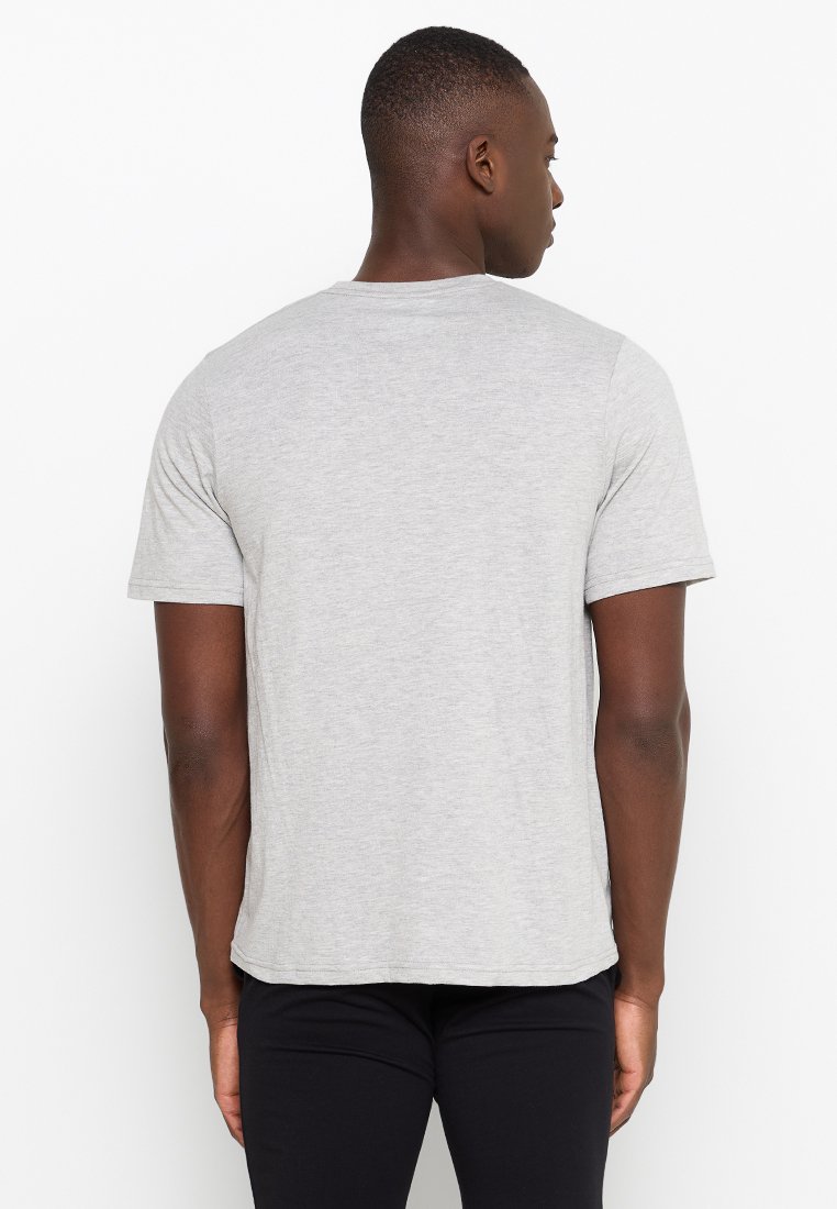 Camiseta gris de manga corta con escote redondo y textura suave y lisa. Diseño simple sin patrones o acentos visibles.