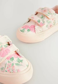Blommönstrade sneakers med en rosa textilöverdel, som har två kardborreband och en strukturerad gummisula.