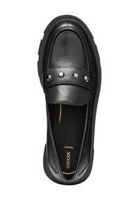 Mocasín de cuero negro con punta redonda, correa decorativa con tachuelas metálicas, superficie texturizada y plantilla acolchada con logo dorado.