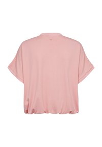 Zadný pohľad na voľnú, krátkym rukávom, svetlo ružovú blúzku s okrúhlym výstrihom a malým gombíkom uprostred hore.
