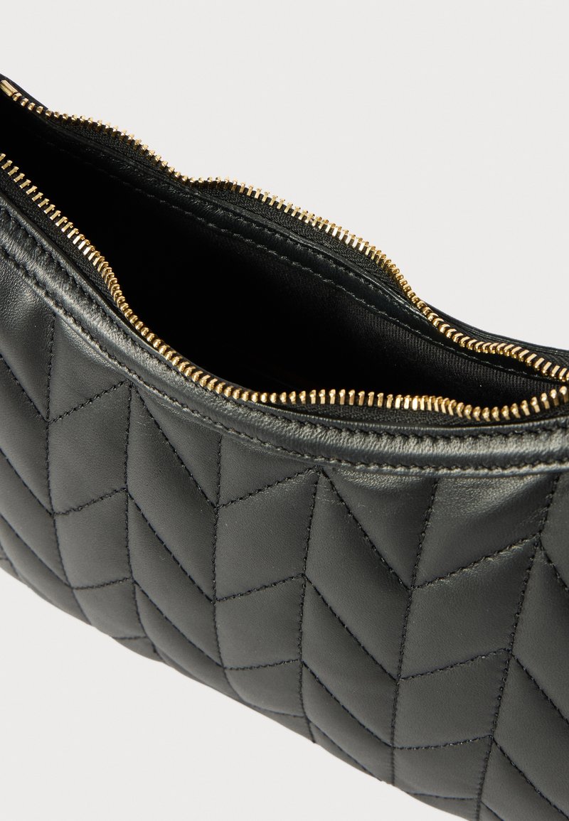 Pochette in pelle trapuntata nera con chiusura a zip. Presenta un motivo geometrico con hardware in tono oro e fodera interna liscia.