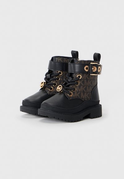 Black ankle boots with a textured logo fabric, gold hardware accents, lace-up front, and rubber soles with a chunky tread pattern.