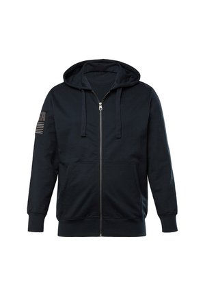 Marineblå zip-up hoodie med en justerbar hætte, frontlommer og et struktureret stof. Har et USA grafik og striber på den ene ærme.