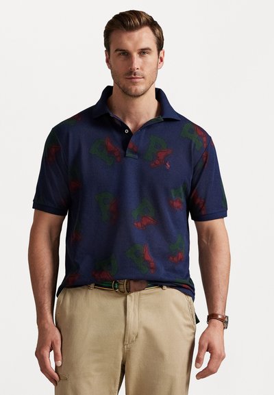 Navy-Poloshirt mit wiederholtem rot-grünem Grafikdruck. Kurzarm, klassischer Kragen, Zwei-Knopf-Blende, Material aus Baumwollmischung.