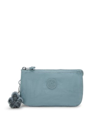 Light blue nylon pouch with zip closure, circular logo detail, and a furry gorilla charm attached. Compact and smooth texture.