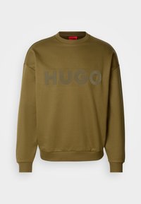 Sweat-shirt vert olive à col rond avec manches longues et « HUGO » embossé sur la poitrine dans la même couleur.