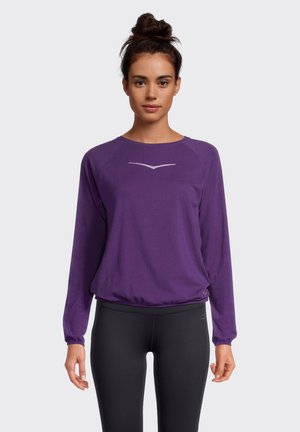Purple long-sleeve top with a round neckline and elastic hem, featuring a subtle gray logo on the chest. Smooth fabric with a relaxed fit.