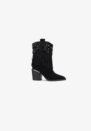 Bottines en daim noir avec un détail de franges prononcé, embellies de clous en argent. Présentent un talon épais et un design à bout pointu.