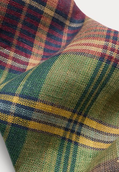 Prim-plan cu material țesut având un model pătrat multicolor cu fire verzi, galbene, roșii, albastre și bej.