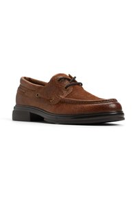 Scarpa da barca in pelle marrone con superficie texture, design con lacci, punta rotonda e suola in gomma nera con lieve tacco. Occhielli in tono oro visibili.
