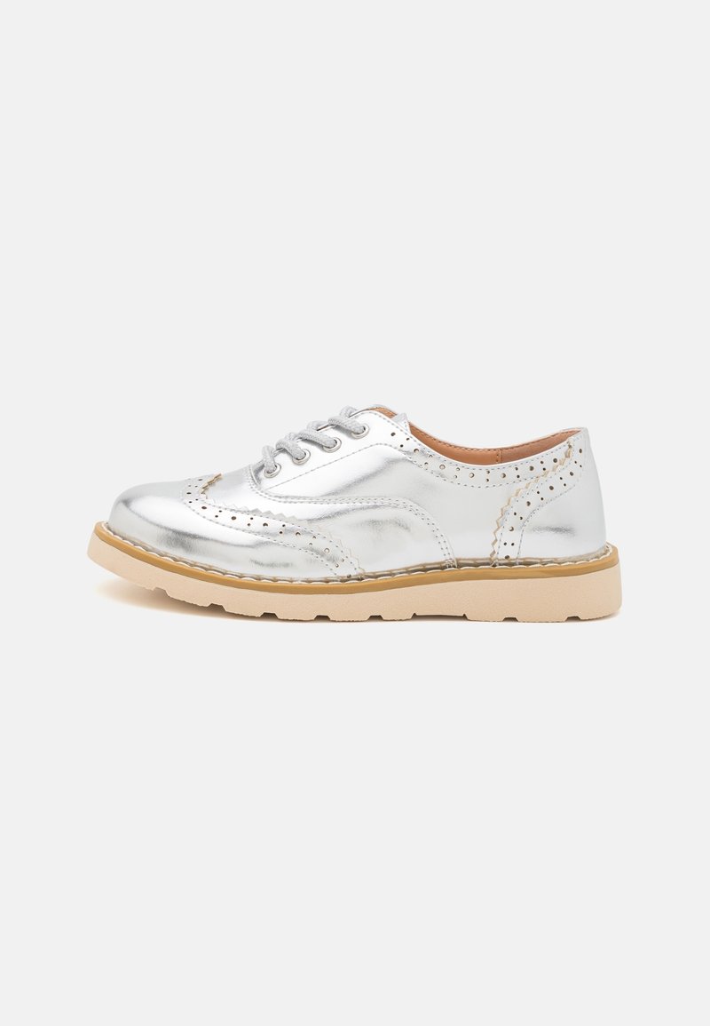 Chaussure oxford à bout golf argent métallisé avec semelle épaisse beige et fermeture à lacets, vue de profil extérieur sur fond blanc.