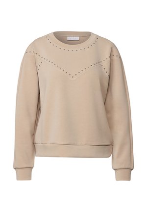 Pull en beige fabriqué dans un tissu doux, avec un col rond, des manches longues et des accents cloutés disposés en motif en chevron.