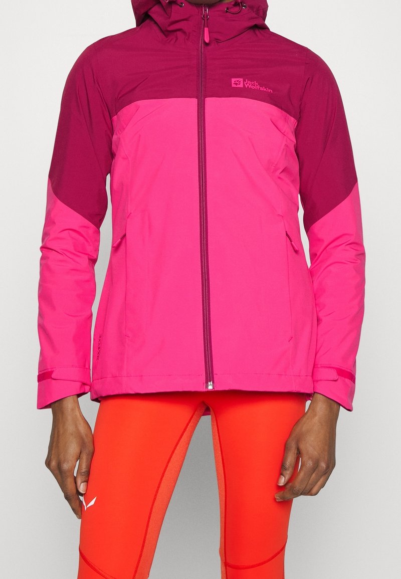 Roze waterdichte jas met capuchon, met een donkerder roze bovenstuk, rits aan de voorkant en zijzakken. Glad oppervlak, sportieve pasvorm.