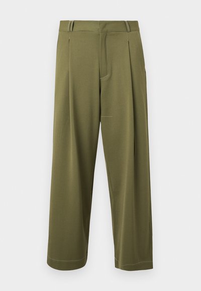 Calças largas de cor verde-azeitona, feitas de um tecido suave, com pregas e costura discreta ao longo da bainha e dos bolsos.