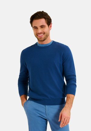Blue knit sweater with ribbed neckline and cuffs, paired with light blue trousers. The fabric appears smooth and lightweight.